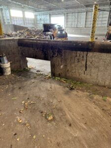 Waste being processed by a loader inside the transfer station for Anchorage Solid Waste Services in Anchorage, AK.