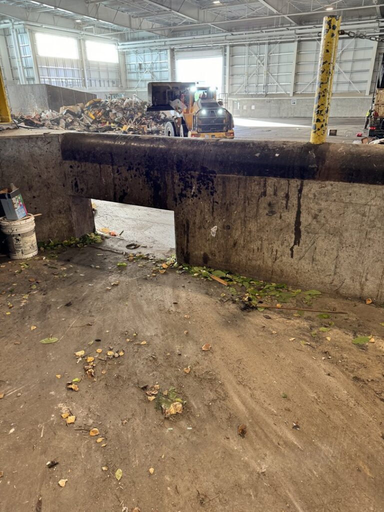 Waste being processed by a loader inside the transfer station for Anchorage Solid Waste Services in Anchorage, AK.