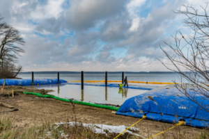 Installation of blue water barriers for a shoreline project by Wilkinson Excavating, Inc. in Meadville, PA