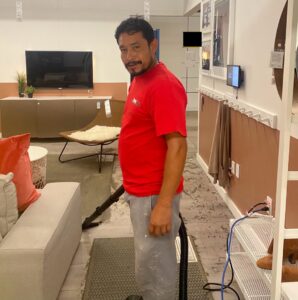 A worker performing water cleanup or professional cleaning in a living room for Professional Restoration in Jersey City, NJ