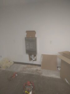 A wall-mounted water cooler and bottle filler installation with exposed plumbing and electrical work by Mr. Affordable LLC in Denver, CO.