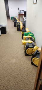 Industrial drying equipment set up in a carpeted hallway for water damage restoration by Get It Done in Sioux Falls, SD.