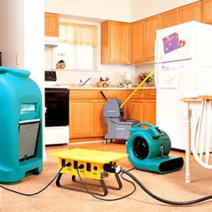 Water damage restoration equipment, including air movers and a dehumidifier, set up in a kitchen by KC Water Damage in Kansas City, MO.