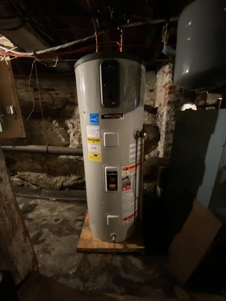 A large water heater with an Energy Star label installed in a basement by Coastal Home Improvements in Greenwood, DE.