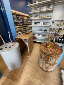 A new water heater next to an old, rusty one, ready for replacement by DemoCraft Commercial Services in Everett, WA