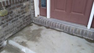 Water pooling on a concrete porch or step, indicating a potential leveling or drainage issue, addressed by American Mud Jack INC in Arvada, CO.