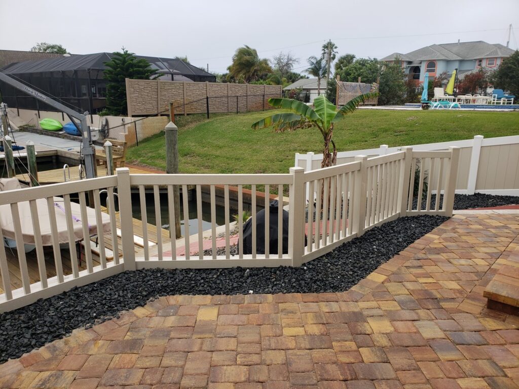 A white vinyl fence installed along a waterfront patio by NGC FENCE INC in Jacksonville, FL.