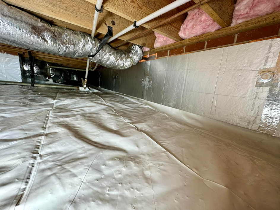 A waterproofed crawlspace with new insulation and a vapor barrier installed by Ramos Waterproofing & Crawlspace Sealing LLC in Durham, NC.