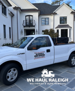 A branded We Haul Raleigh junk removal truck parked at a residential job site in Raleigh, NC, ready to haul items.