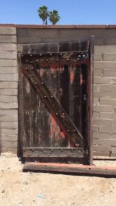 A weathered wooden gate, potentially needing repair or replacement, by Affordable Fence & Gates in Tucson, AZ.