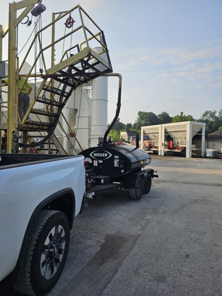 A Weiler trailer truck parked near the industrial asphalt plant facility of Northeast-Paving in Bangor, ME