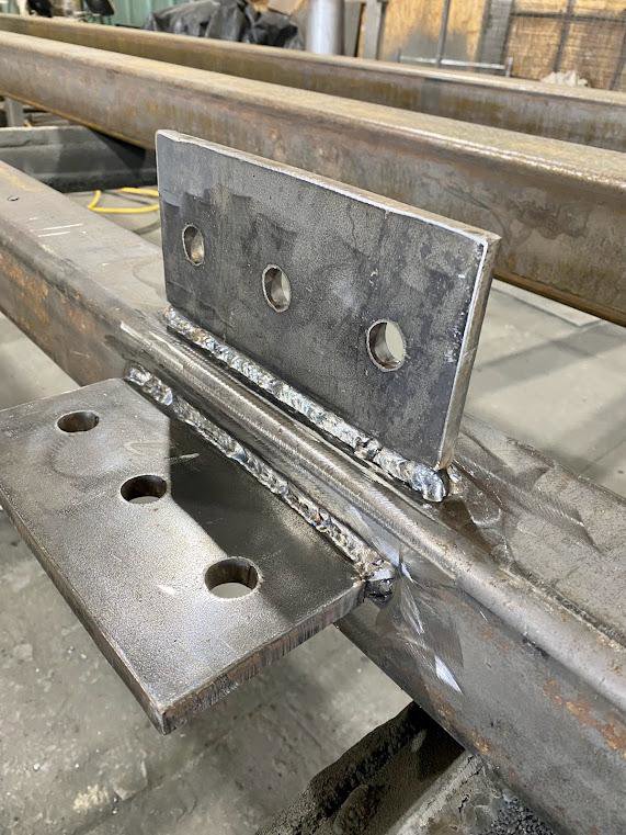 A close-up of a metal beam with a newly welded plate and bracket, demonstrating precision welding by Jeremy's Welding & Handyman in West Jordan, UT.