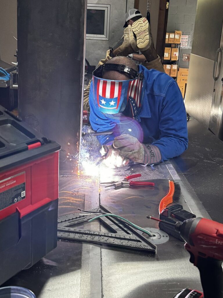 A skilled welder from ProKitchen Solutions fabricating a kitchen exhaust system in Russiaville, IN