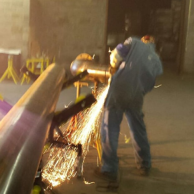 A welder grinding metal, creating sparks, at Charlotte's Welding Service in Rock Hill, SC