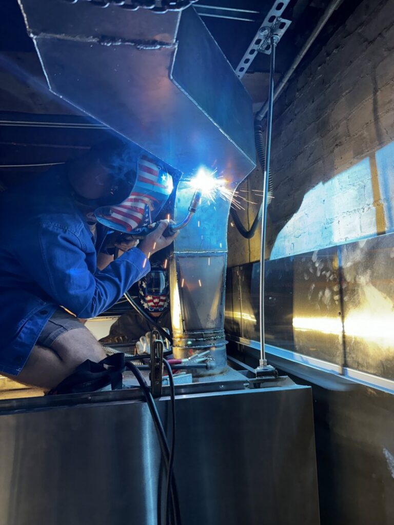 A ProKitchen Solutions technician welding kitchen ventilation ductwork in Russiaville, IN
