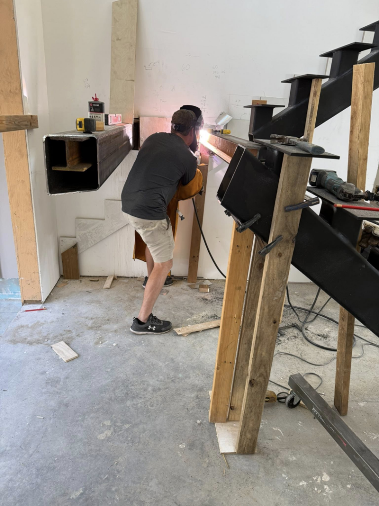A worker welding metal stairs during a construction project by Sanddollar Building & Remodeling Inc in Hilton Head Island, SC.