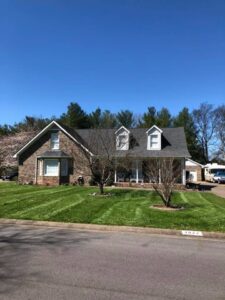 A residential house with a neatly mowed lawn and healthy trees, maintained by Ratliff Landscape and Tree Service LLC in Murfreesboro, TN