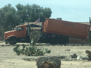 A Wesco Disposal truck with a tilted roll-off dumpster for junk removal services in Phoenix, AZ.