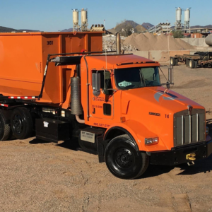 A Wesco Disposal truck with a roll-off dumpster at a material processing yard in Phoenix, AZ.