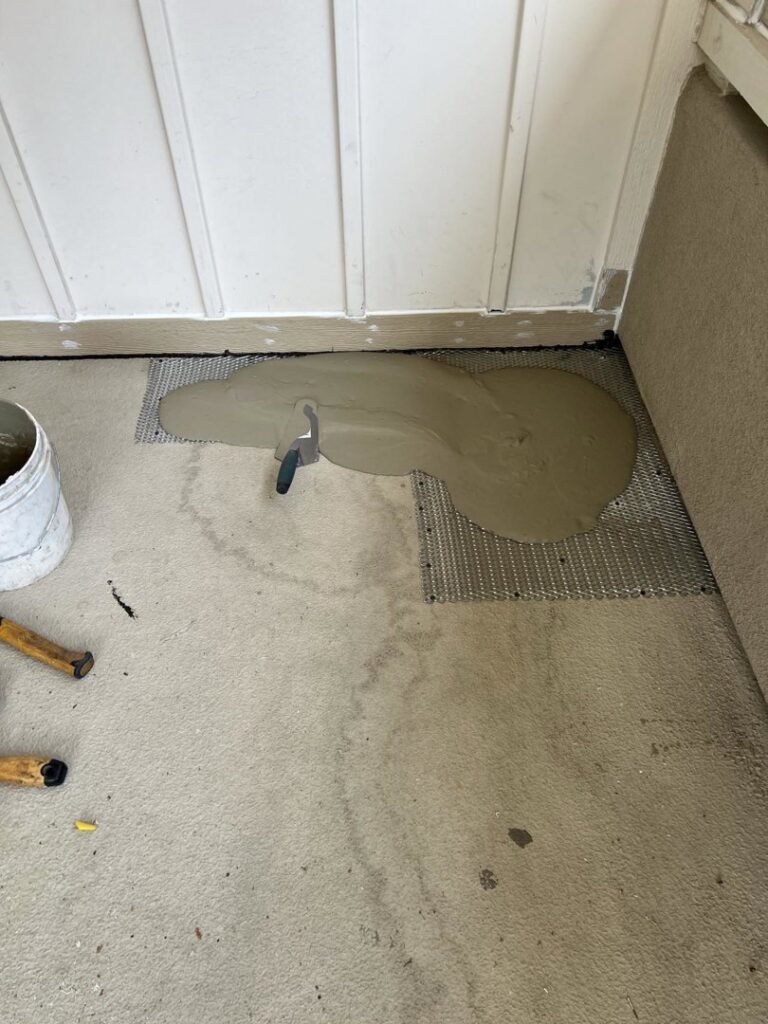 Wet cement or mortar being applied over a mesh for floor preparation by Sal Handyman Services in Canyon Country, CA