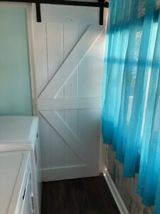 A newly installed white barn door in a home by Dynamic Design & Remodeling in Westport, CT