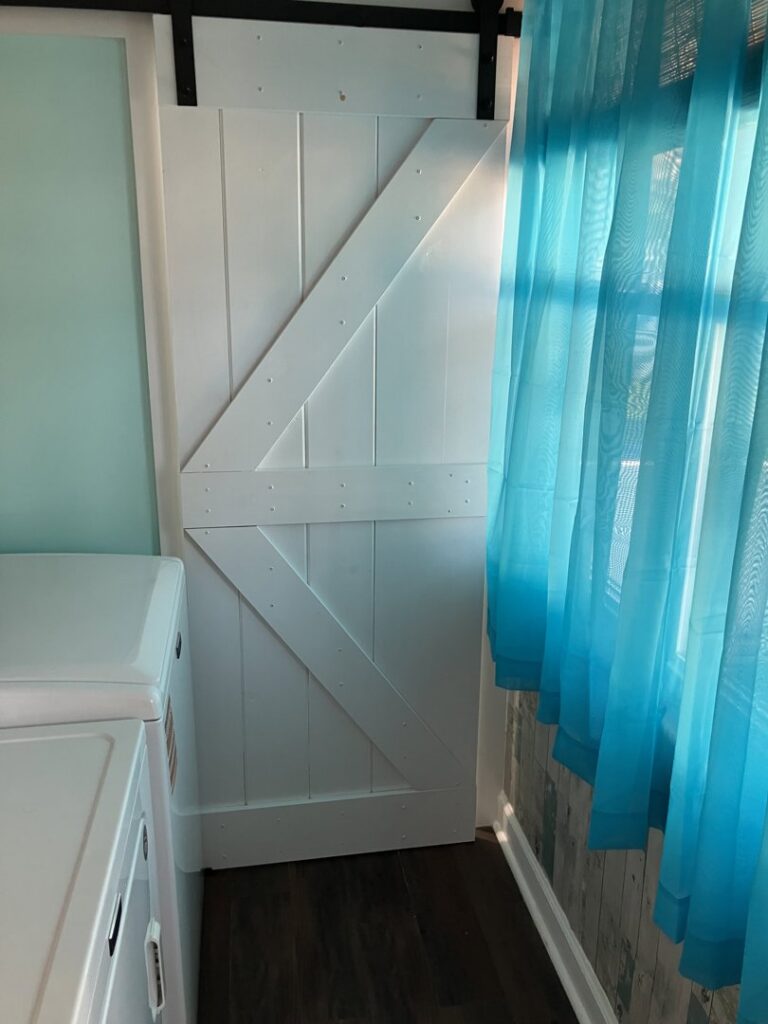 A newly installed white barn door in a home by Dynamic Design & Remodeling in Westport, CT