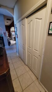 Newly installed white bifold closet doors in a home hallway by My Quality Handyman in Fresno, CA.