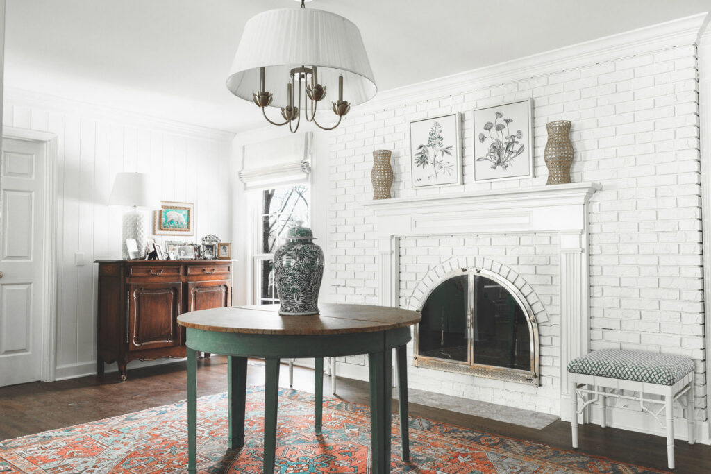 An interior room with a white painted brick fireplace and a chandelier by Harpeth Painting, LLC. in Nashville, TN.