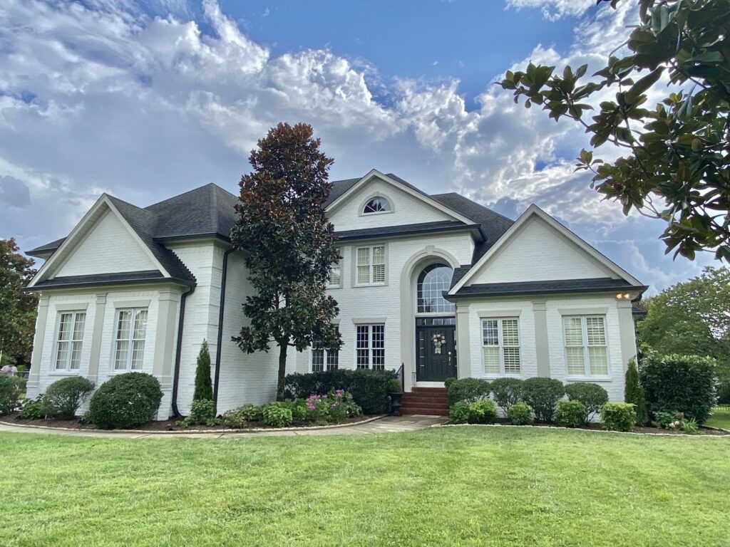 The freshly painted white brick exterior of a large house by Harpeth Painting, LLC. in Nashville, TN.
