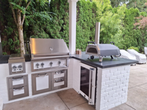 An outdoor kitchen with white brick base and built-in grill installed by Eagle Outdoor Living LLC in Freeland, WA.