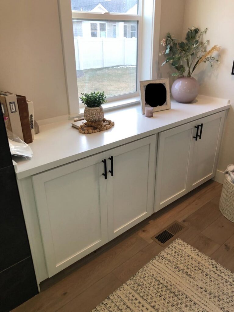 White built-in cabinets with a clean white countertop installed under a window by The Huckleberry Handyman in Meridian, ID.