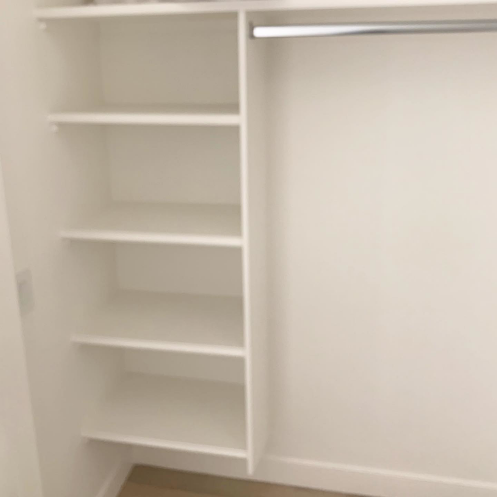 Custom white closet shelving and hanging rod installation by Mountain Door and Trim in Phoenix, AZ.