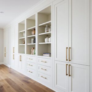 Long wall of white custom built-in cabinets and open shelving with gold hardware by Corkery Customs & Remodeling LLC in Philadelphia, PA