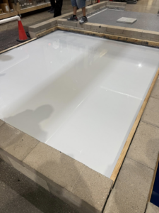 White epoxy floor installation sample by CC&J Construction, INC in Bernville, PA, framed by concrete blocks.
