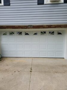 A stylish white garage door featuring decorative windows, installed by Lucas Overhead Doors in Erie, PA.