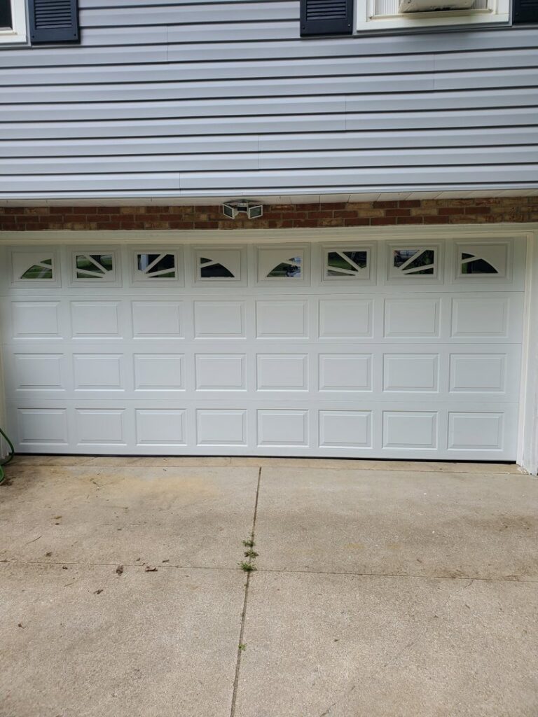 A stylish white garage door featuring decorative windows, installed by Lucas Overhead Doors in Erie, PA.