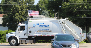 A white L & W Garbage Service truck with an American flag, parked, ready for junk removal and recycling services in Lincoln, NE.