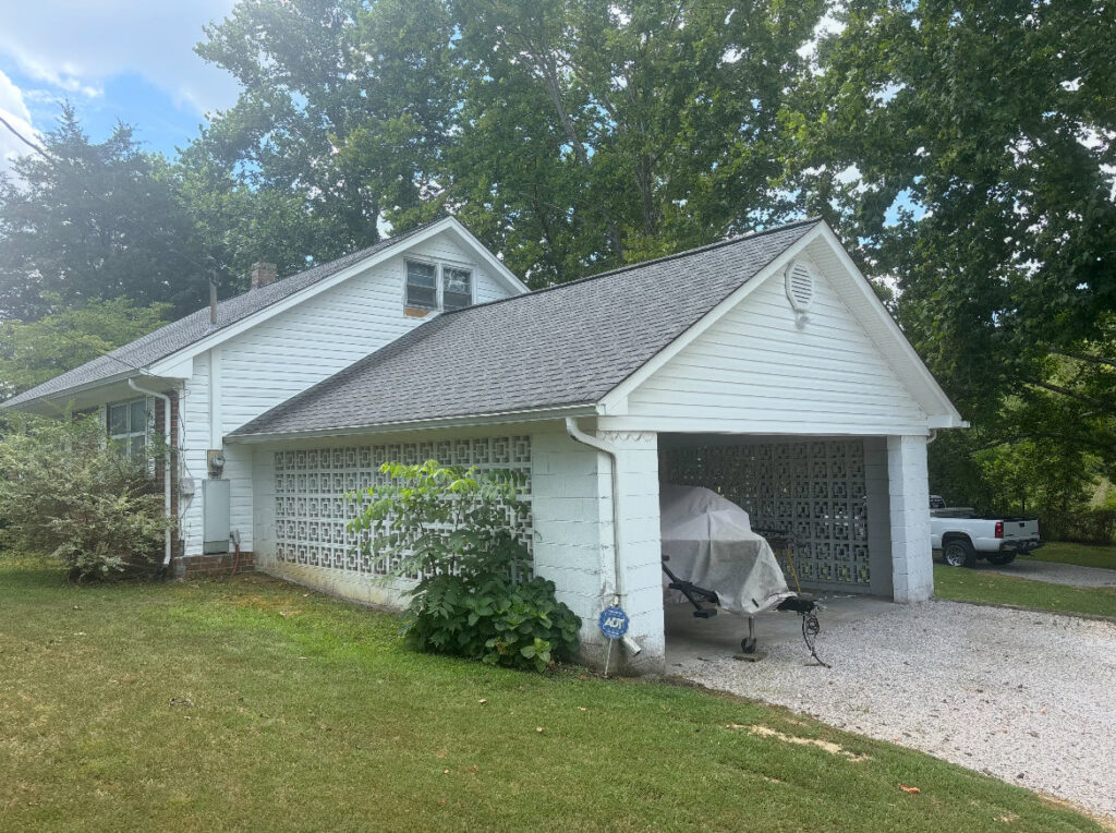 White house with a new roof and gutters installed by Knoxville Guttering and Home Improvements in Knoxville, TN.