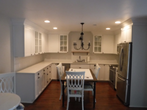 A newly remodeled kitchen featuring white cabinets and stainless steel appliances by Husbands On Call in Virginia Beach, VA.