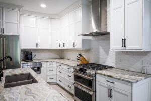 A bright kitchen remodel with white cabinets, stainless steel appliances, and granite countertops by Kore Construction LLC in Cincinnati, OH.