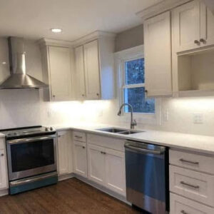 A newly installed kitchen with white cabinets, stainless steel appliances, and a modern sink, completed by Orion Construction Services in Duluth, MN.