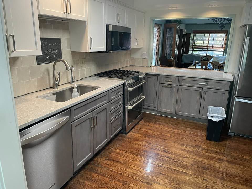 A kitchen with white refaced cabinets and integrated built-in appliances by Cincinnati Cabinet Refacing in Cincinnati, OH.