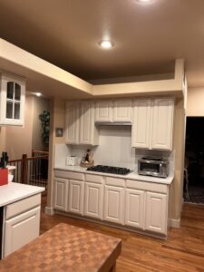 A renovated kitchen featuring white cabinets and clean countertops by Greg Unseth Painting & Exteriors in Colorado Springs, CO