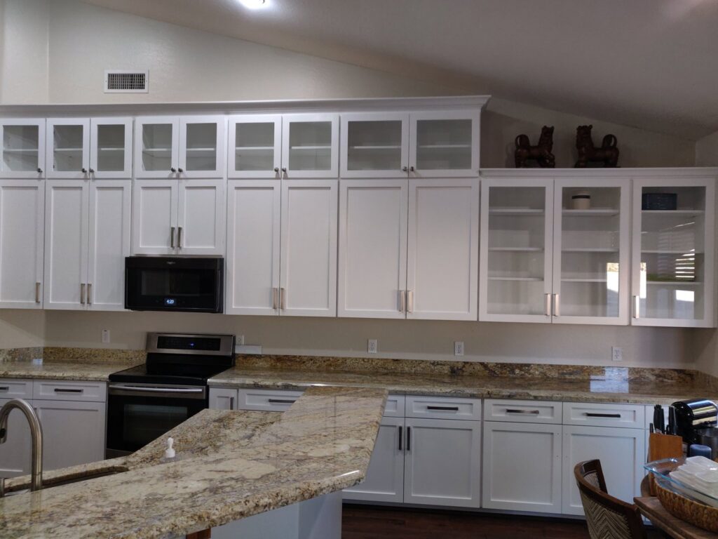 Kitchen featuring white cabinets, granite, and a unique wooden countertop section by Camelback Cabinets in Gilbert, AZ