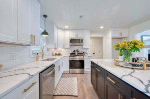 A stunning white kitchen remodel featuring a dark island and quartz countertops by Slater Cabinets and More in Springfield, MO.