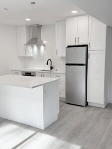 A bright, newly remodeled kitchen with white cabinets, a central island, and new flooring by JP. Remodel Service LLC in Everett, WA.