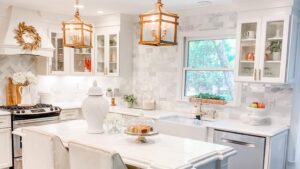 A bright white kitchen remodel with a marble subway tile backsplash, a large island, and elegant pendant lighting by Pro Finishes NC, LLC in Raleigh, NC.