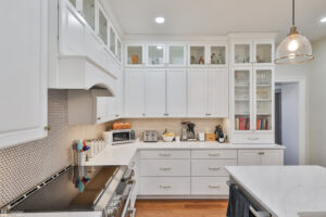 A bright white kitchen remodel with shaker cabinets and hexagonal tile backsplash by Shafer Construction, LLC in Bethlehem, PA.