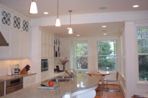 A renovated kitchen with white cabinets, granite countertops, and a large island by S.N. Peck Builder, Inc. in Chicago, IL.