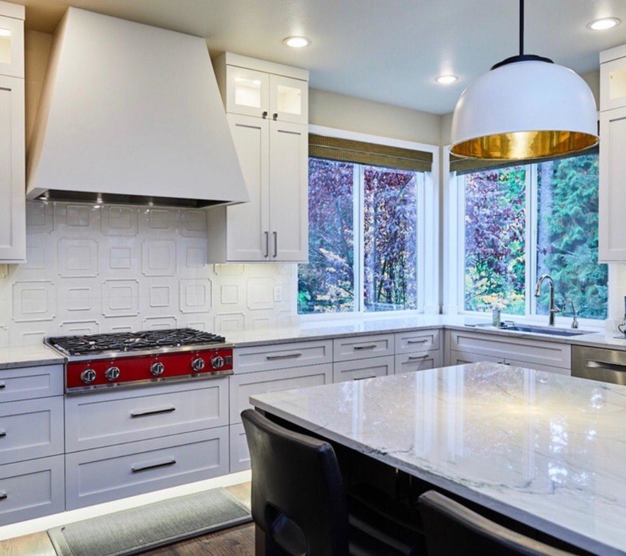 A bright white kitchen renovation with patterned tile backsplash and marble-look countertops by Atlantic Tile & Granite in Kent, WA.